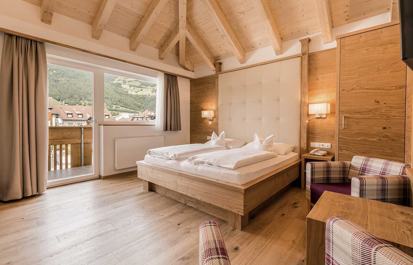 Coppietta sul letto in una stanza dell'Hotel in Valle Isarco in Alto Adige